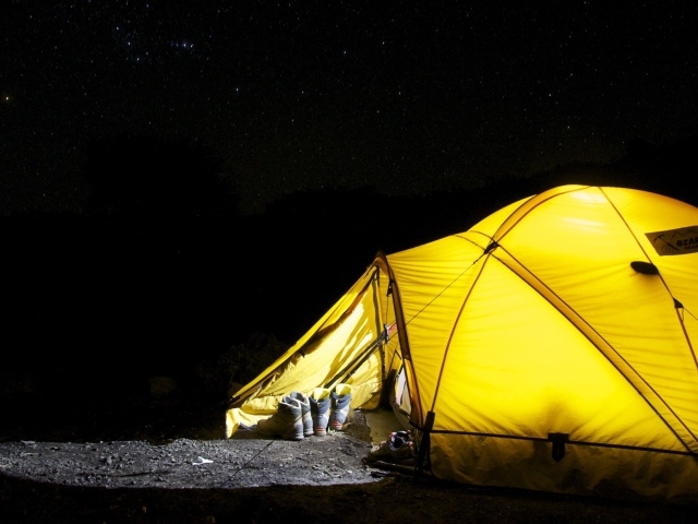 Желтая палатка туристов под ночным небом