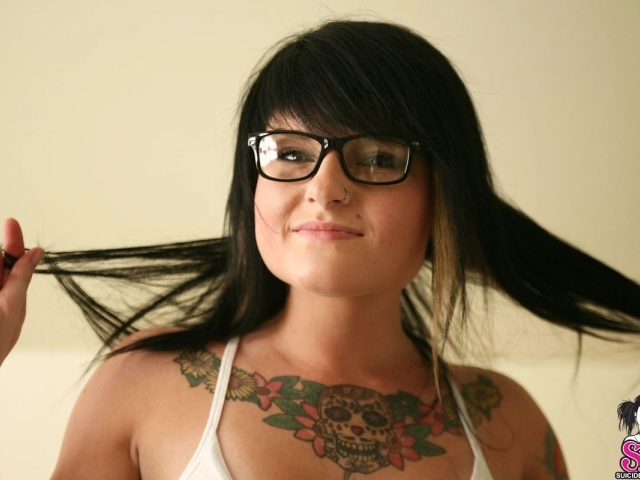 Брюнетка в очках с тату на груди