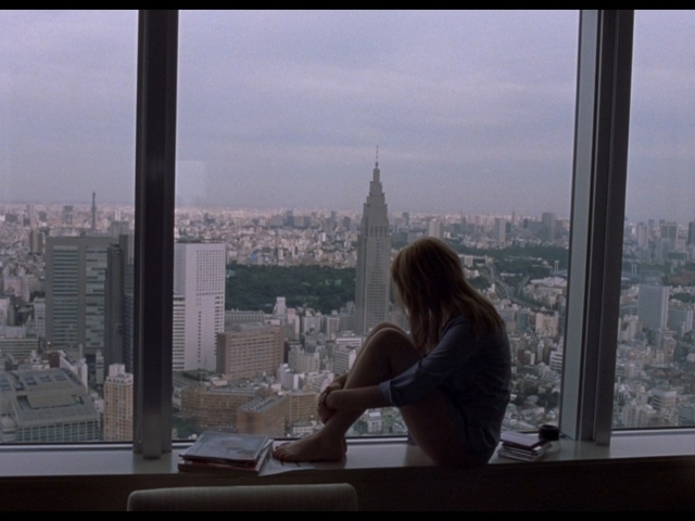 Девушка Скарлетт Йоханссон смотрит на город в окно