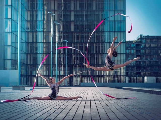 Гимнастки с лентами на площади перед небоскребом