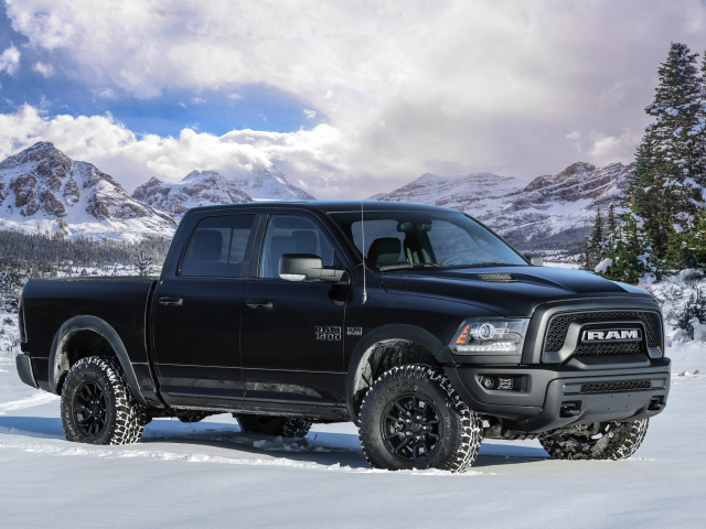 Автомобиль пикап Ram 1500 Rebel Black, 2017 года на фоне заснеженных гор 