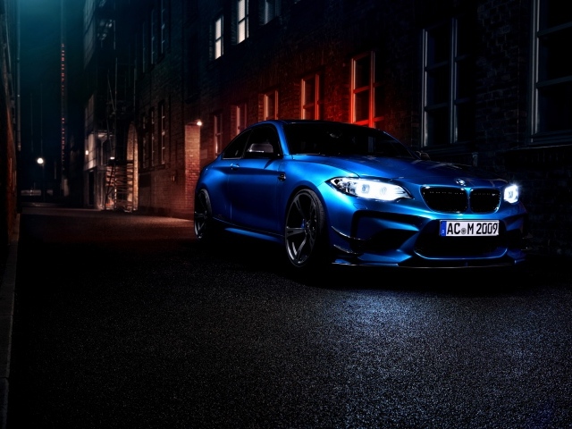 Синий автомобиль BMW M2 на улице города ночью