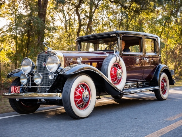 Стильный ретро автомобиль  Cadillac V16 бордового цвета
