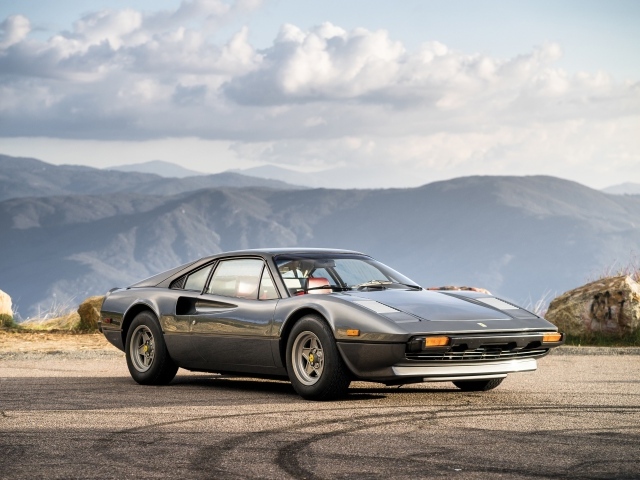 Суперкар Ferrari 308 gts серого цвета,   на фоне гор 