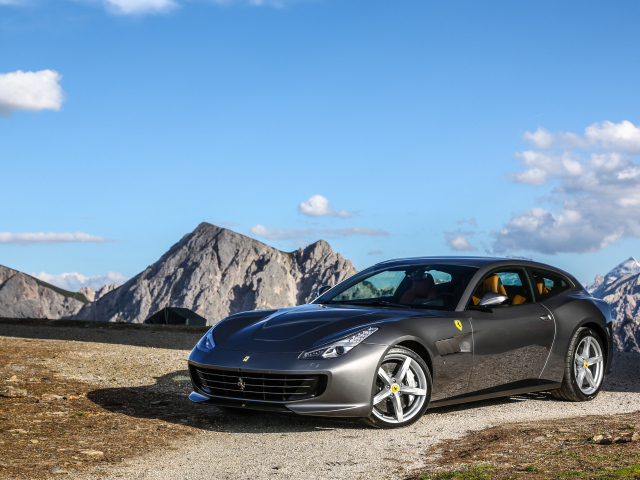 Серебристый автомобиль Ferrari GTC4Lusso на фоне голубого неба 
