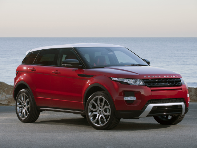 Красный автомобиль Land Rover Caractere на фоне океана