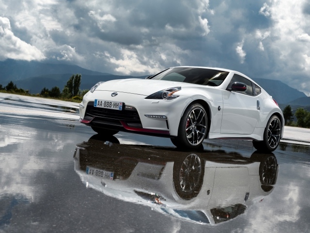 Белый автомобиль Nissan 370z Nismo, 2018 на фоне пасмурного неба