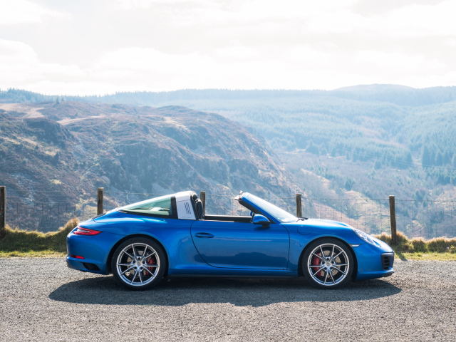 Голубой автомобиль кабриолет Porsche 911 Targa 4S на фоне гор