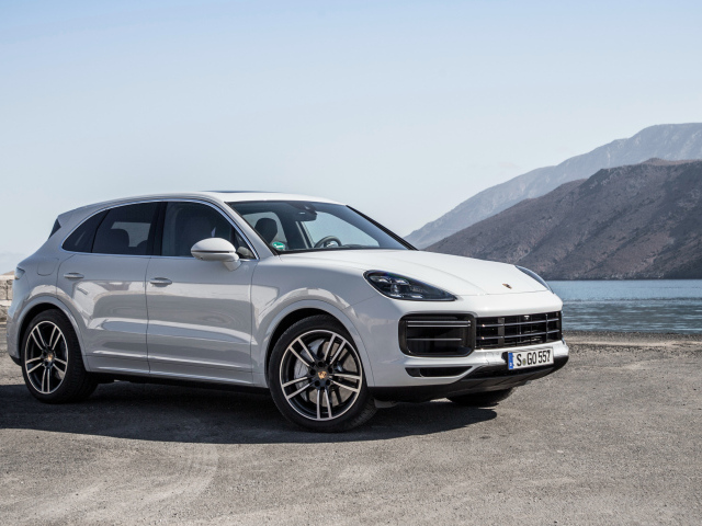 Белый автомобиль Porsche Cayenne Turbo, 2018 у воды