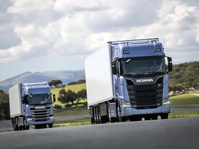 Два голубых грузовика Scania S 700 на трассе