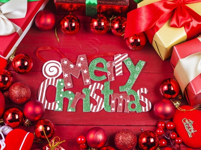 Праздничная надпись Merry Christmas на красном фоне с игрушками и подарками