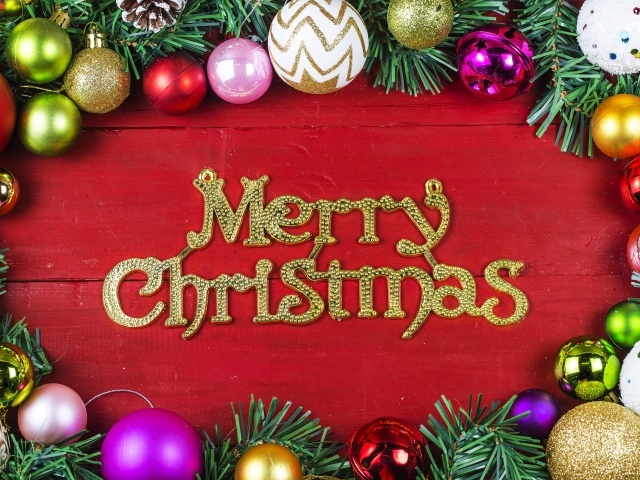 Надпись Merry Christmas на красном фоне с елочными игрушками на Рождество