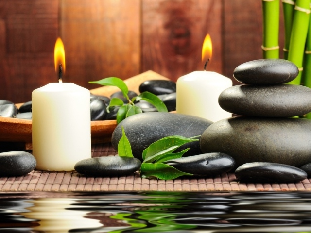 Черные камни дзен с двумя горящими свечами