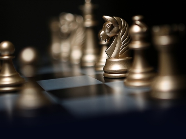 Золотые шахматные фигуры на шахматной доске