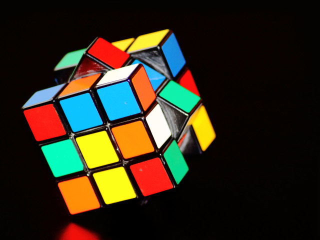 Разноцветный кубик Рубика на черном фоне