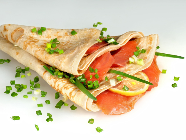 Аппетитный блин с красной рыбой и зеленым луком