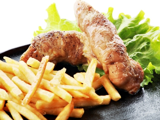 Куриные рулеты с картофелем фри и зелеными листьями салата