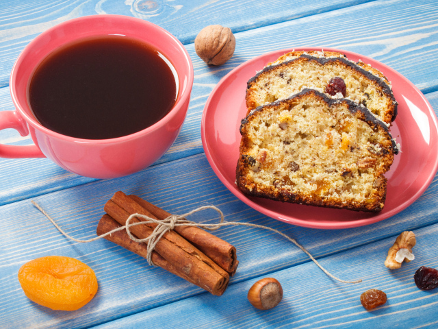 Кекс с корицей, орехами и курагой на столе с чашкой чая