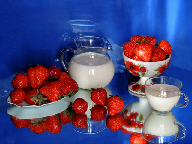 Свежие аппетитные ягоды клубники на столе с молоком