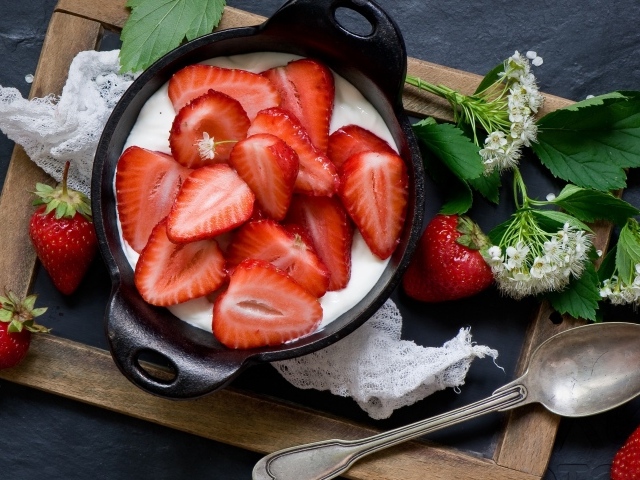 Свежая клубника с йогуртом на завтрак на столе с белым цветком