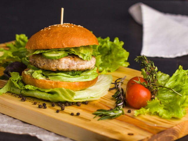 Гамбургер с зеленью на разделочной доске  