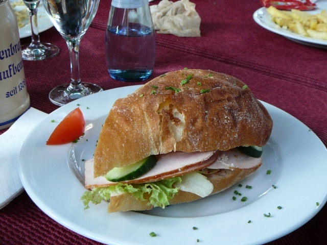 Сэндвич с ветчиной и овощами на столе в ресторане