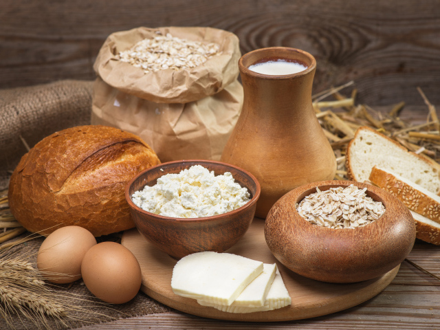Натюрморт сыр, хлеб, яйца и молоко на столе 