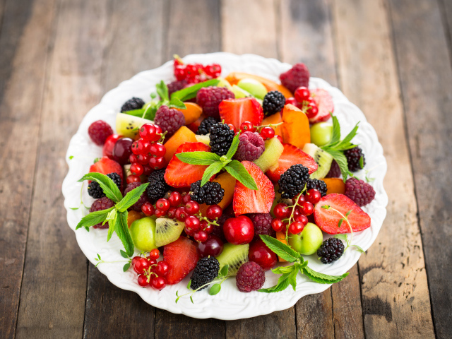 Аппетитные свежие фрукты на белой тарелке 