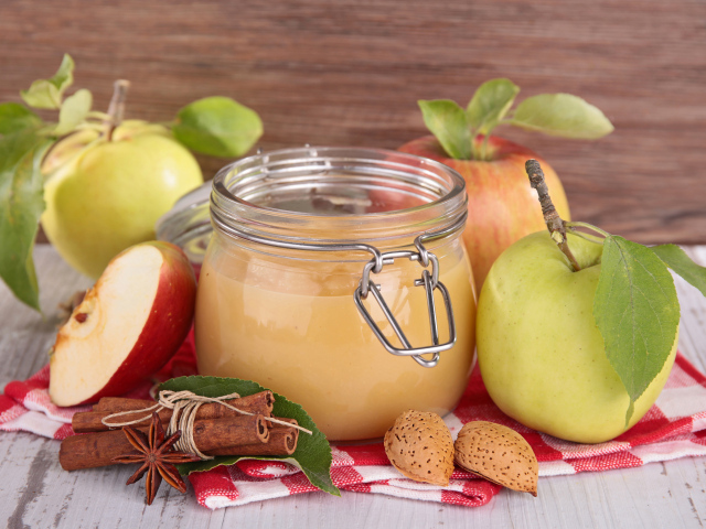 Банка яблочного джема с пряностями на столе