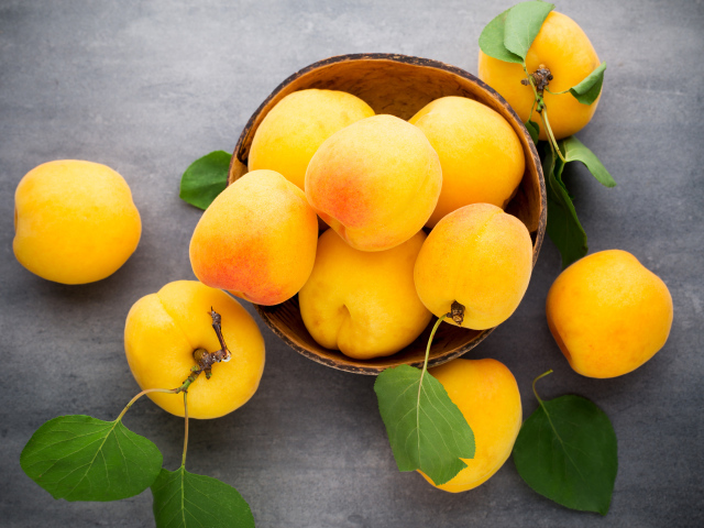 Крупные свежие желтые абрикосы на столе