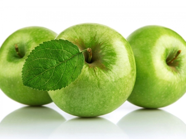 Три зеленых яблока на белом фоне 