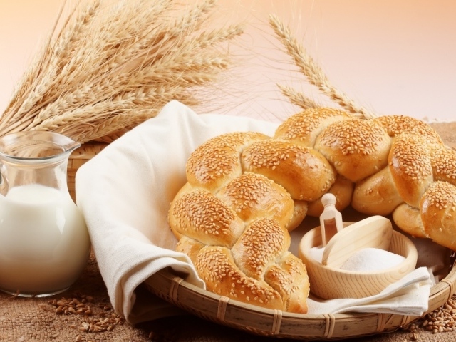 Хлебобулочное изделие и кувшин молока на столе