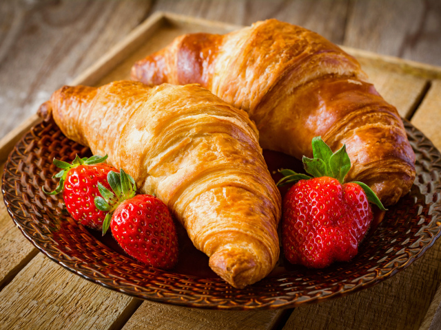 Два свежих круассана со свежей клубникой