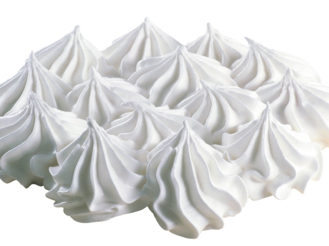 Воздушные взбитые сливки на белом фоне