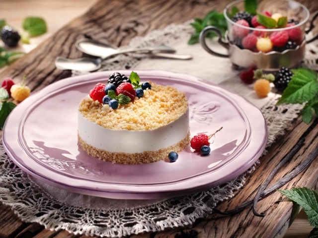 Аппетитный чизкейк с ягодами малины, черники и ежевики на большом блюде