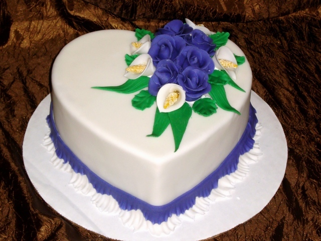 Красивый торт в форме сердца украшен цветами