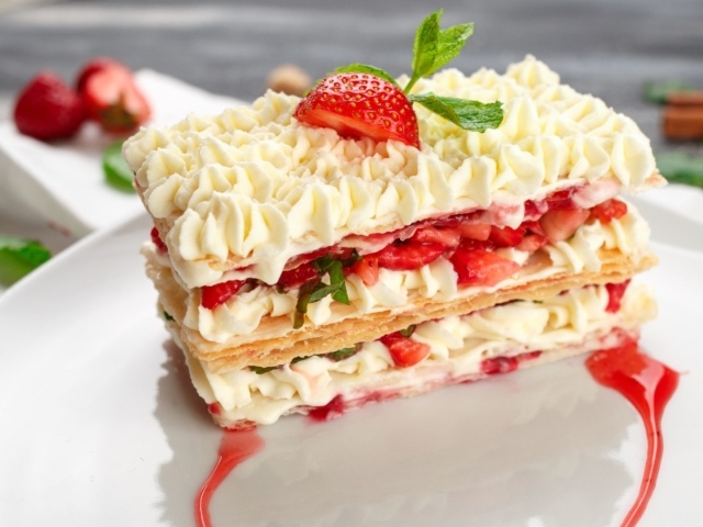 Вкусное сладкое пирожное с кремом и клубникой