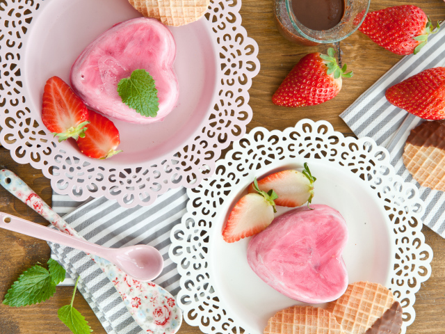 Десерт в форме сердца на тарелке со свежей клубникой