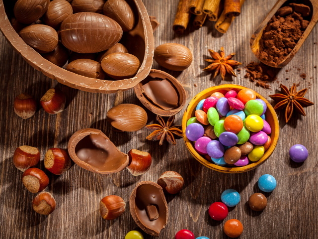 Разноцветные конфеты на столе с шоколадными яйцами и орехами