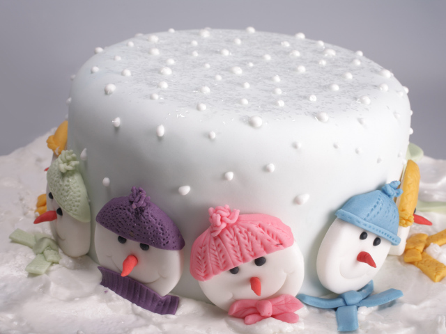 Новогодний торт украшен снеговиками из сахара