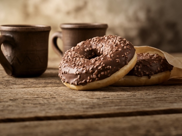 Сладкие круглые пончики с шоколадом на столе 