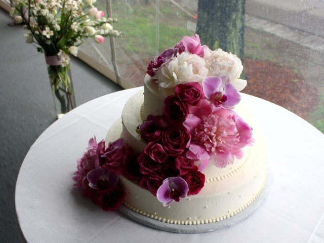 Большой свадебный торт украшен живыми цветами