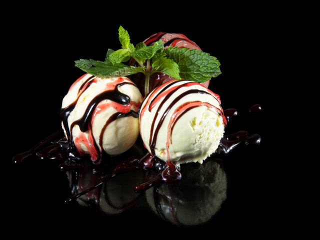 Три шарика мороженого с джемом на черном фоне