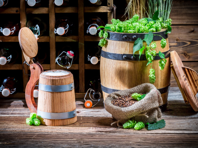 Бокал пива и деревянная бочка с хмелем на столе