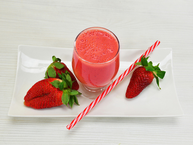 Бокал клубничного коктейля со свежей клубникой и трубочкой