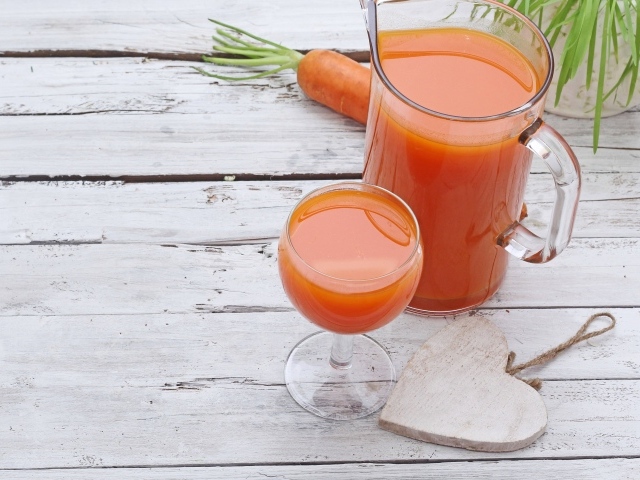 Морковный сок в кувшине на столе с  бокалом