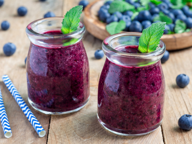 Вкусный черничный смузи с ягодами свежей черники на столе