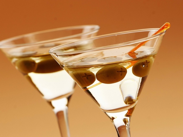 Напиток мартини в бокалах с оливками на кремовом фоне