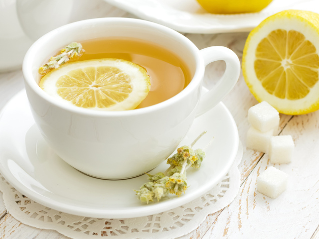 Зеленый чай с лимоном в белой чашке 