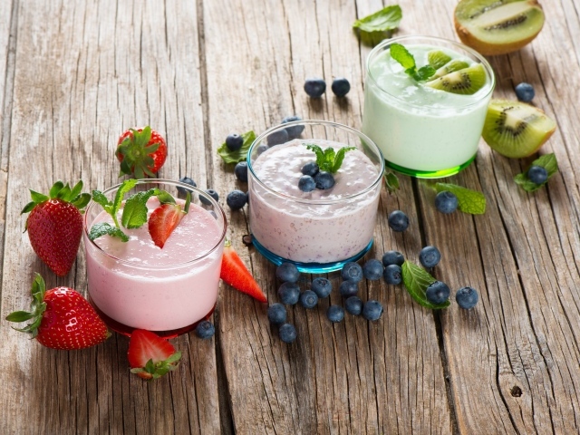Три стакана смузи с клубникой, киви и черникой и свежими ягодами